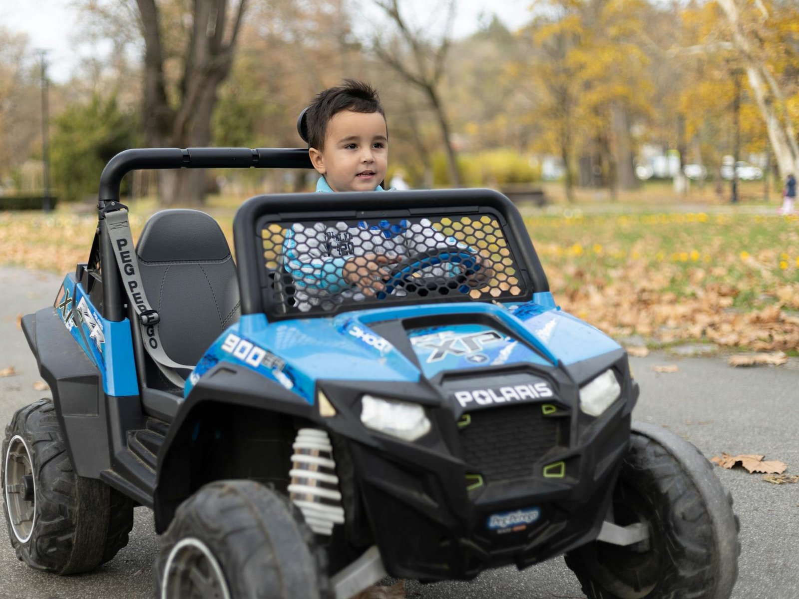 small boy riding a electric toy quad bike in the park